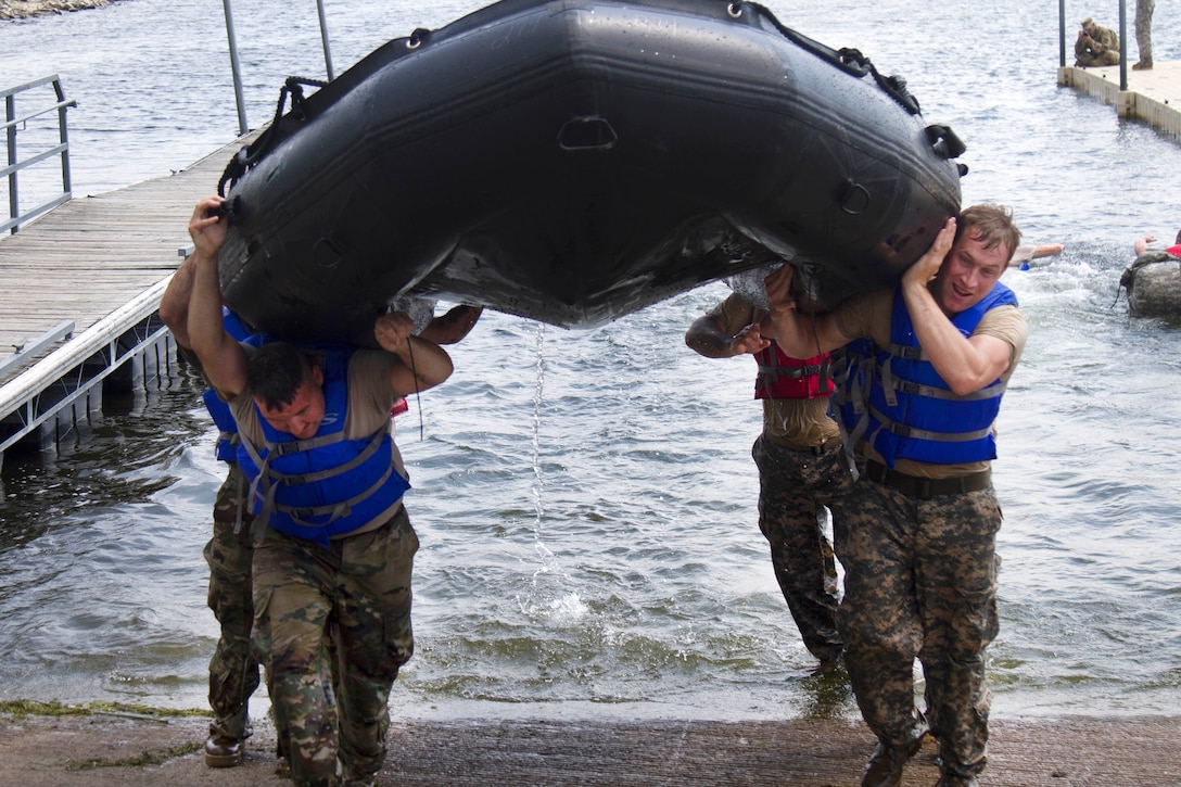 Guardsmen carry their boat out of the water.
