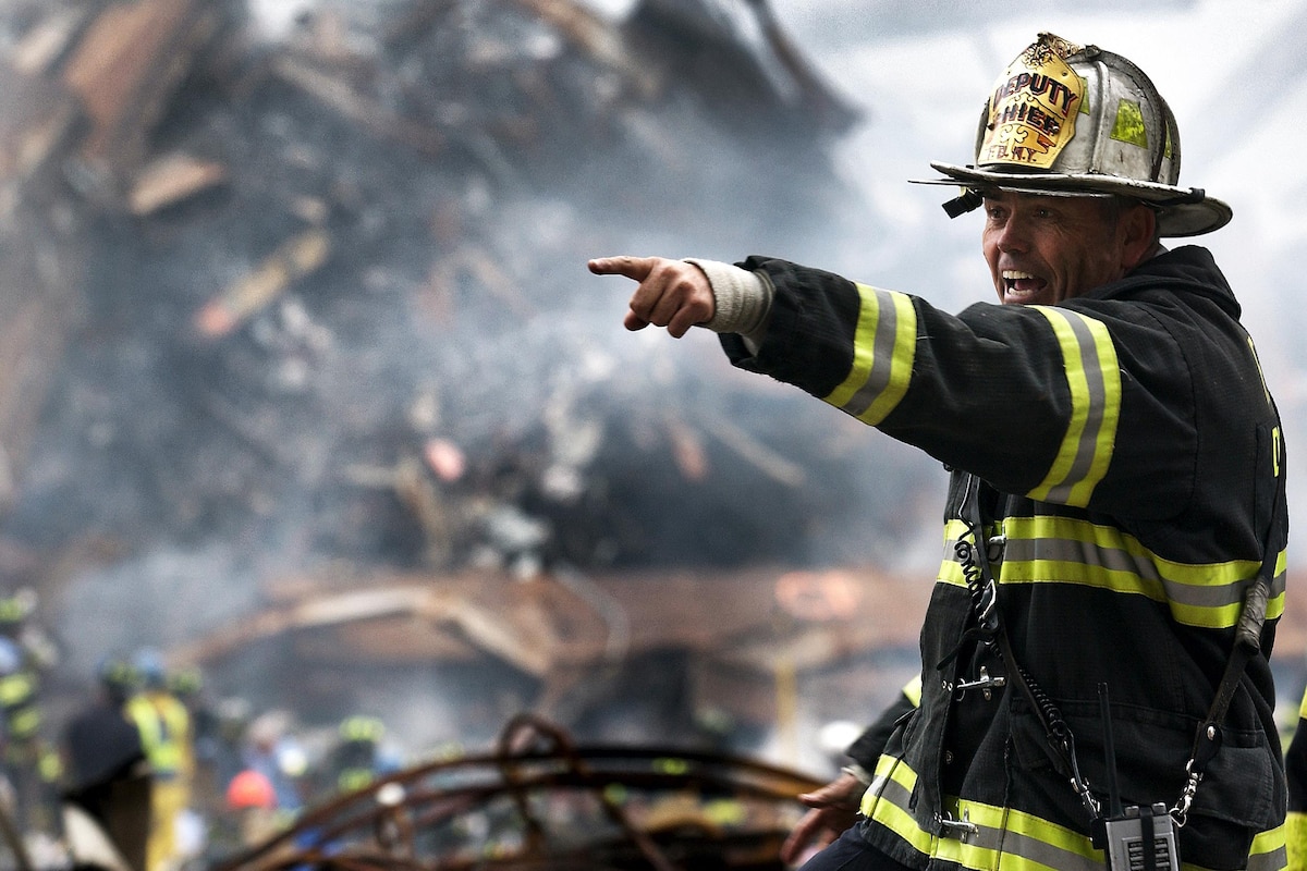 A firefighter instructs rescue teams clearing through debris at ground zero.