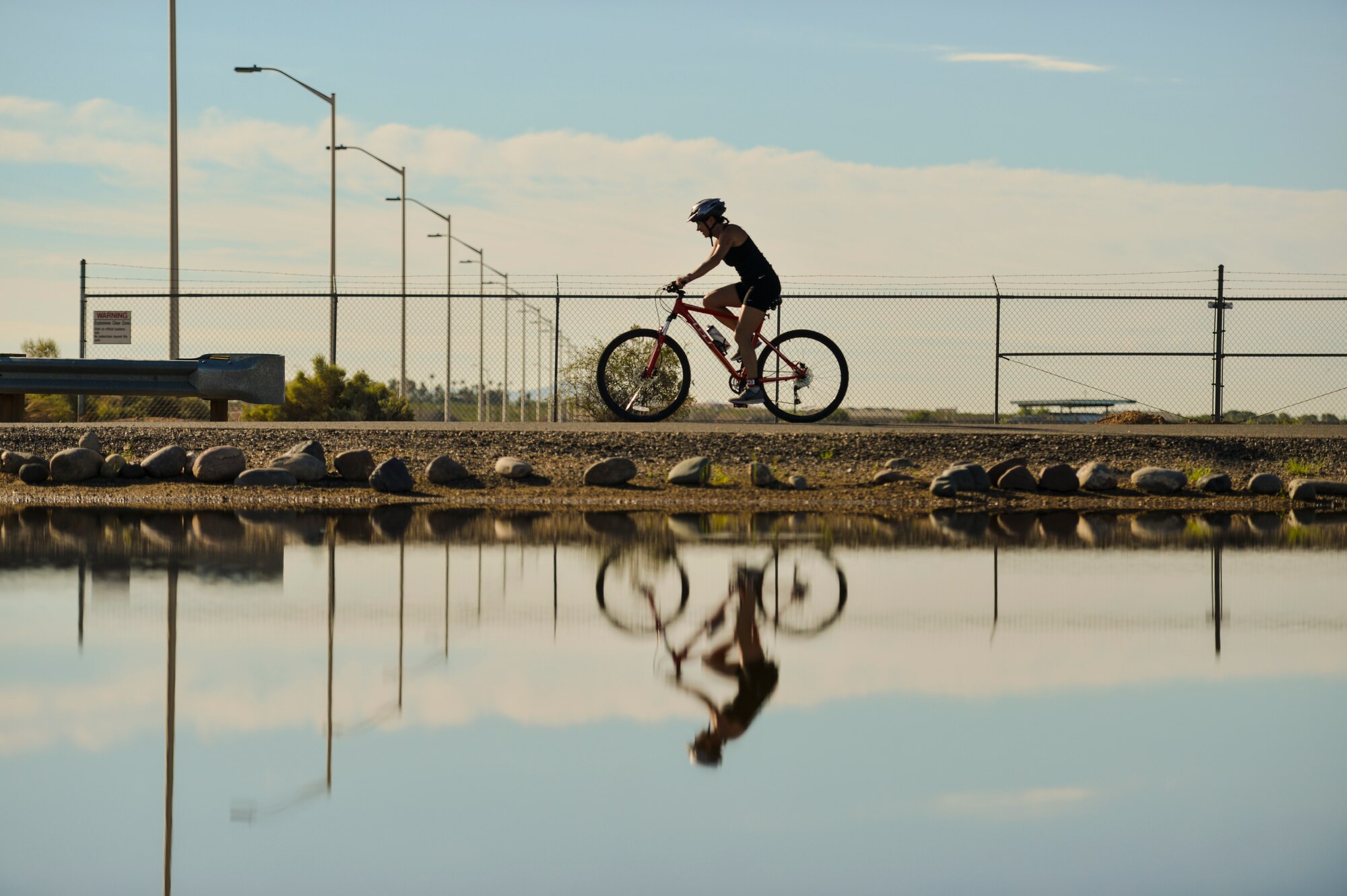 A Team Luke triathlon participant rides her bike during the Luke Triathlon held at Luke Air Force Base, Ariz., Aug. 19, 2017. The biking portion of the competition encompassed a total distance of 13 miles. (U.S. Air Force photo/Airman 1st Class Caleb Worpel)