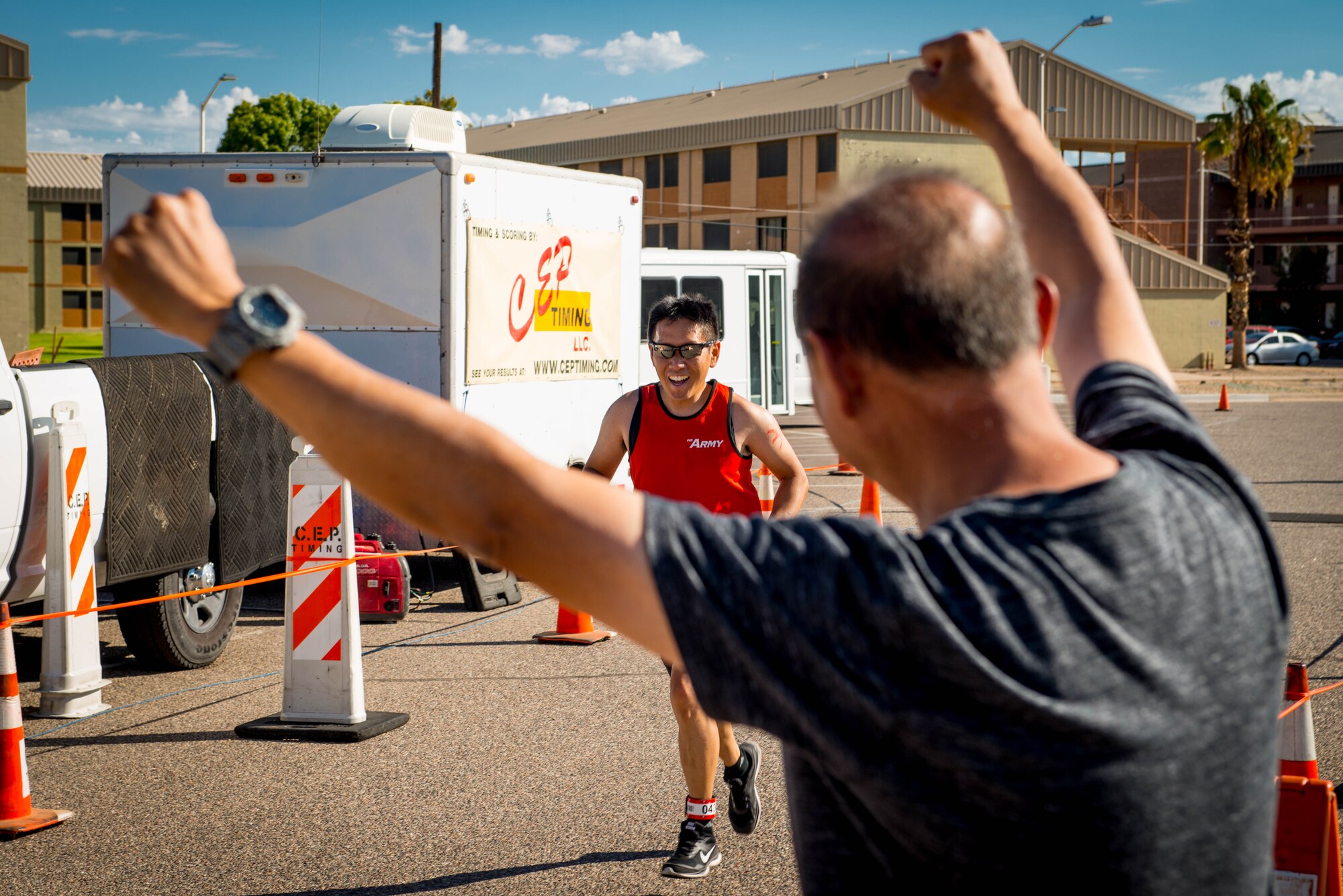 A Team Luke triathlon participant crosses the finish line after completing a triathlon held at Luke Air Force Base, Ariz., Aug. 19, 2017. Participants swam 400 meters, biked 13 miles and ran 3.1 miles to finish the competition. (U.S. Air Force photo/Staff Sgt. Jensen Stidham)