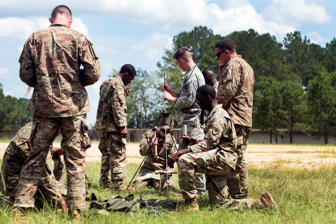 Soldiers assemble an OE-254 antenna group.