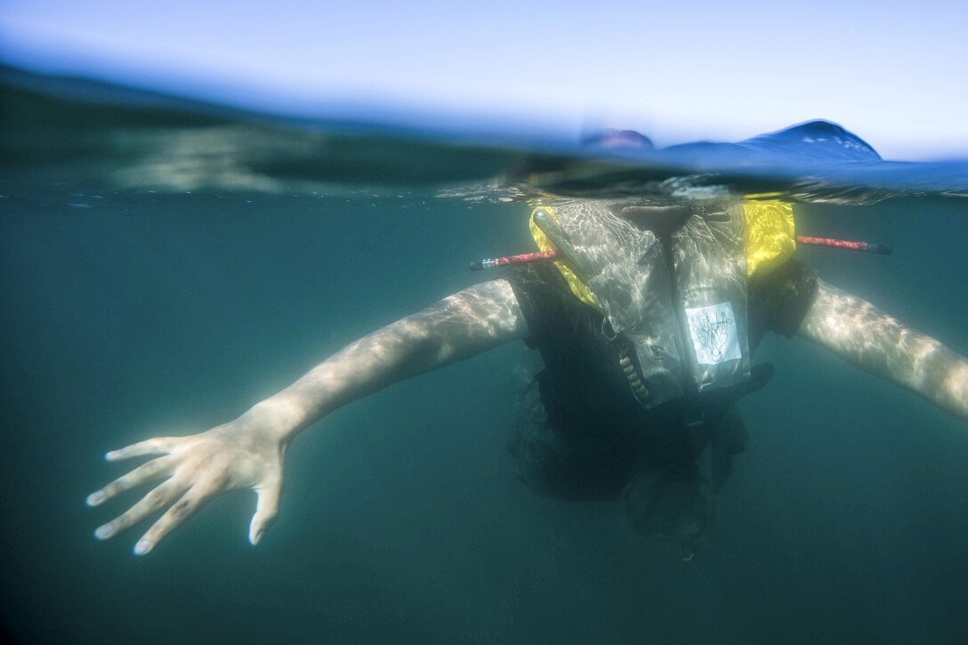 This image shows a Marine swimming with a life vest during an annual surf qualification.