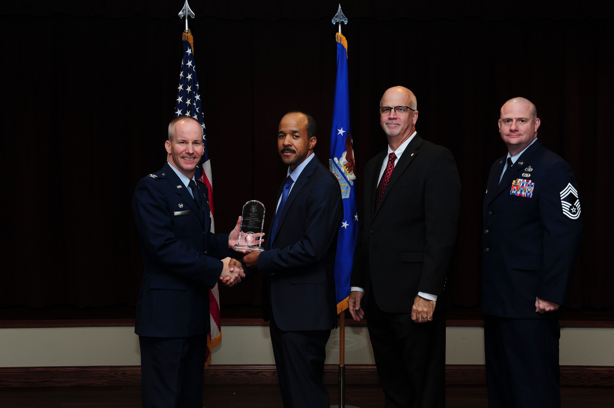 Tyree Wilborne, National Air and Space Intelligence Center employee, received the Maj. Gen. Harold E. Watson Award from Col. Sean Larkin, NASIC commander and Curt Rowland, NASIC chief scientist, here Aug. 15, 2017. The Watson award is given to an individual that has placed NASIC at the top of their personal priorities, and is a selfless champion for NASIC and its people, and is completely dedicated to organizational service. (U.S. Air Force photo by Staff Sgt. Stephanie Longoria)