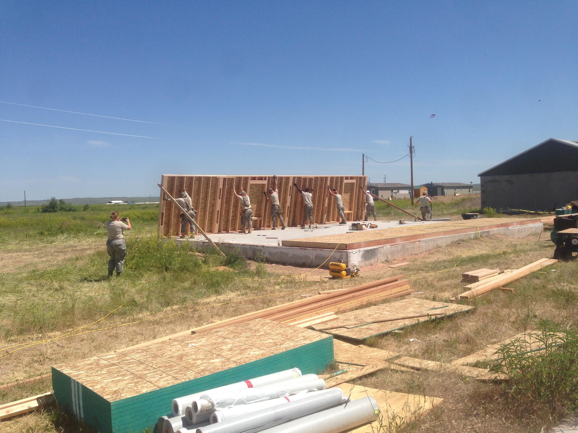 Members of the 106th Rescue Wing Civil Engineering assigned to the New York Air National Guard, put up walls for a house that was left unfinished by a contractor at Crow Agency, Montana June 7, 2017. 32 members from the New York Air National Guard’s 106th Rescue Wing’s Civil Engineer Squadron and five members from the 106th Force Support Squadron, here, deployed for training June 4 to June 17, 2017, at Crow Agency, Montana, in an effort to build and renovate homes for military service veterans from the Native American tribe Crow Nation. (U.S. Air Force photo by Maj. Ronnie Maloney)