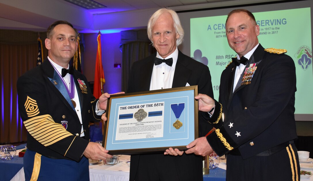 Author and businessman Robert Edsel, center, receives a medal as an honorary member of the Order of the 88th Division from Commanding General of the 88th Regional Support Command Maj. Gen. Patrick Reinert, right, and 88th RSC Command Sgt. Maj. Earl Rocca during an 88th RSC Headquarters and Headquarters Company banquet in Warrens, Wis. on Aug. 19, in honor of the 100 Year Anniversary of the establishment of the 88th Division.