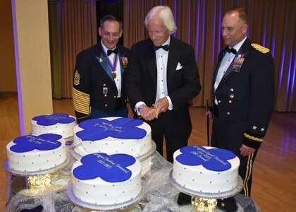 Commanding General of the 88th Regional Support Command Maj. Gen. Patrick Reinert, right, and 88th RSC Command Sgt. Maj. Earl Rocca along with author and businessman Robert Edsel, center, conduct a cake cutting ceremony during an 88th RSC Headquarters and Headquarters Company banquet in Warrens, Wis. on Aug. 19, in honor of the 100 Year Anniversary of the establishment of the 88th Division.