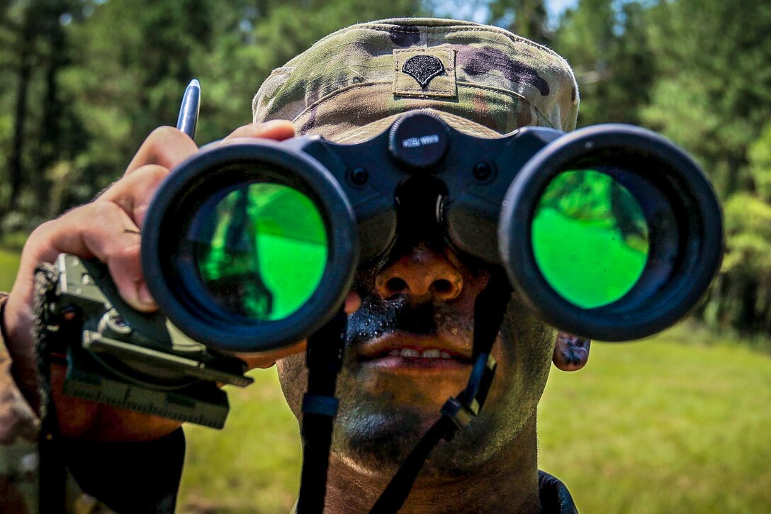 A soldier looks through his binoculars during a competition.