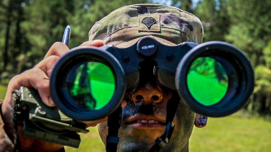 A soldier looks through his binoculars during a competition.