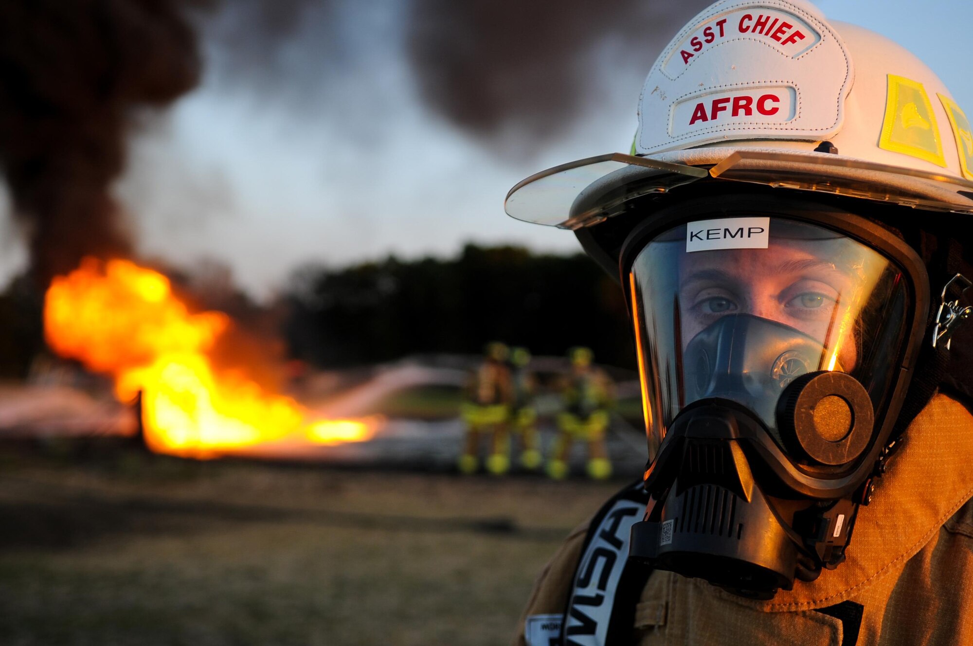 U.S. Air Force 1st Lt. Catherine Irvine, 307th Civil Engineer Squadron, Barksdale AFB, La., borrows protective gear to observe U.S. Air Force firefighters battle a controlled fuel burn during exercise Patriot Warrior at Sparta/Fort McCoy Airport, Wis., Aug. 11, 2017.