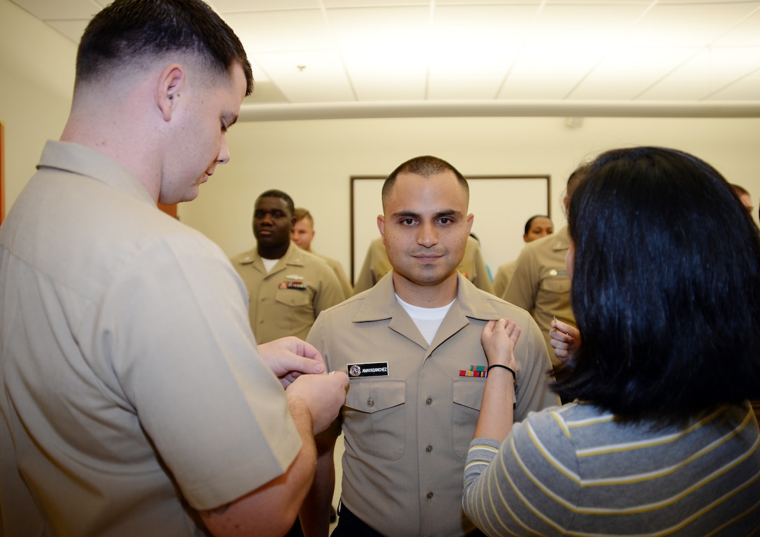 Petty Officer 2nd Class Luis E. AmayaSanchez, center, corpsman, Laboratory Department, Naval Branch Health Clinic-Albany, Ga., is meritoriously promoted to his current rank during a ceremony held at the clinic, Aug. 7. Chief Petty Officer Louis D. Simpson, left, senior enlisted leader, NBHC-Albany, and AmayaSanchez’s wife, pinned on the chevrons.