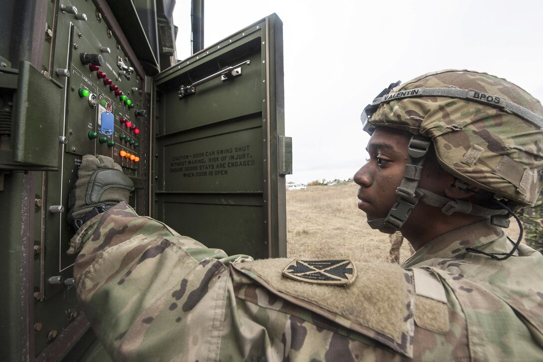 A soldier works with a control panel.