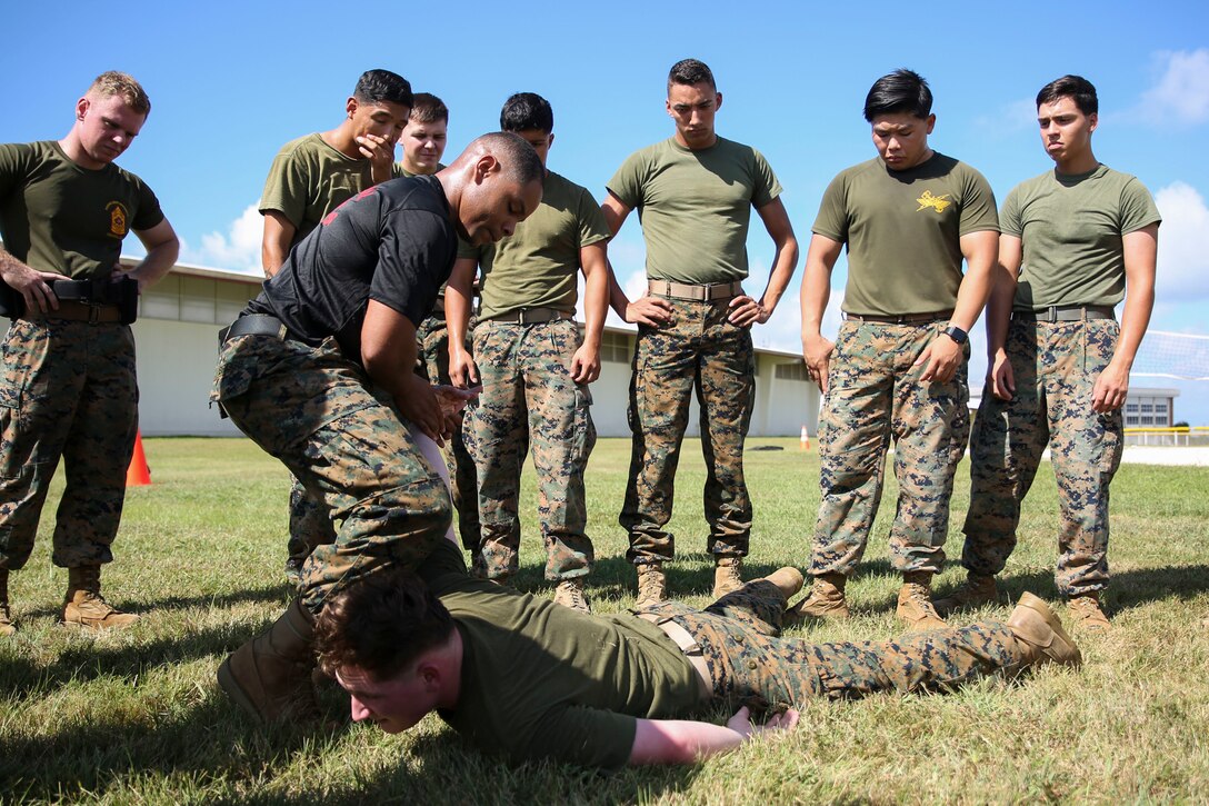 Staff Sgt. Leo Briggs, the staff non-commissioned officer in charge of Camp Hansen Camp Guard, executes a restraining maneuver on Lance Cpl. Alexander Madden, an infantryman with Headquarters and Service Company, 3d Intelligence Battalion, III MEF, during non-lethal weapons training August 16, 2017. Briggs, a non-lethal weapons instructor, conducted non-lethal weapons and restraint technique training with members of the Camp Guard on Camp Hansen, Okinawa, Japan, where they provide support to the base Provost Marshall Office and Marine Corps Police Department. (U.S. Marine Corps photo by Sgt. Tiffany Edwards)