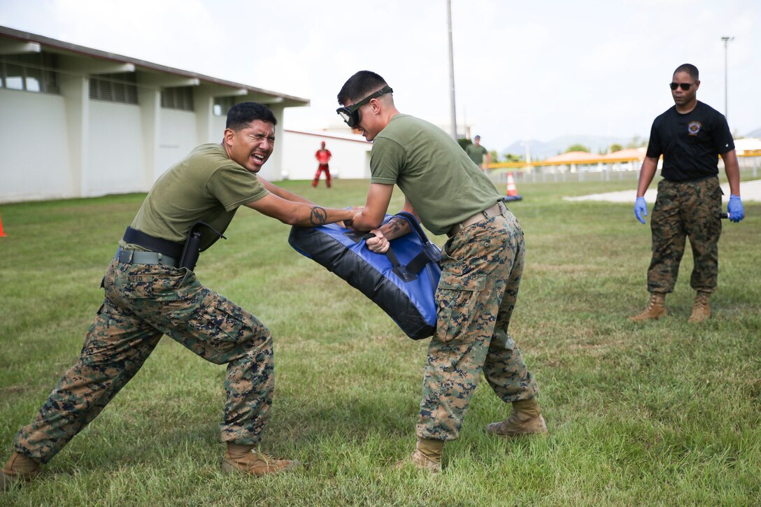 Cpl. John Nieto, a forward observer with 1st Brigade, 5th Air-Naval Gunfire Liaison Company, executes an oleoresin capsicum fight-through drill during non-lethal weapons training August 16, 2017. Nieto is currently assigned as an augment to Camp Guard on Camp Hansen, Okinawa, Japan, where he provides support to the base Provost Marshall Office and Marine Corps Police Department. Nieto is a native of Washington D.C. (U.S. Marine Corps photo by Sgt. Tiffany Edwards)
