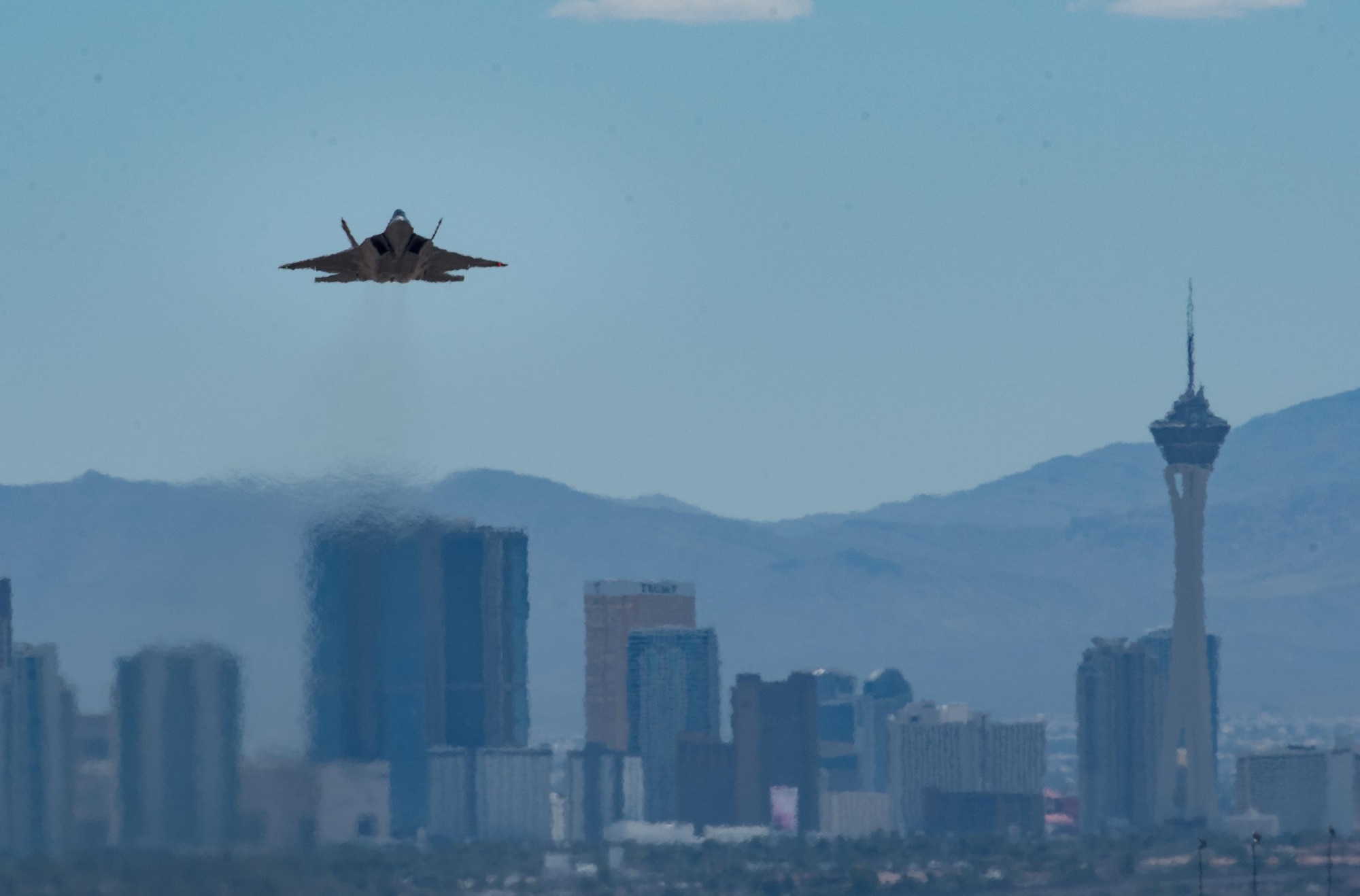 An 94th Fighter Squadron F-22 Raptor takes off with the Las Vegas, Nev. Skyline behind it during Red Flag 17-4 at Nellis Air Force Base, Nev., Aug. 17, 2017.  (U.S. Air Force photo by Staff Sgt. Carlin Leslie)
