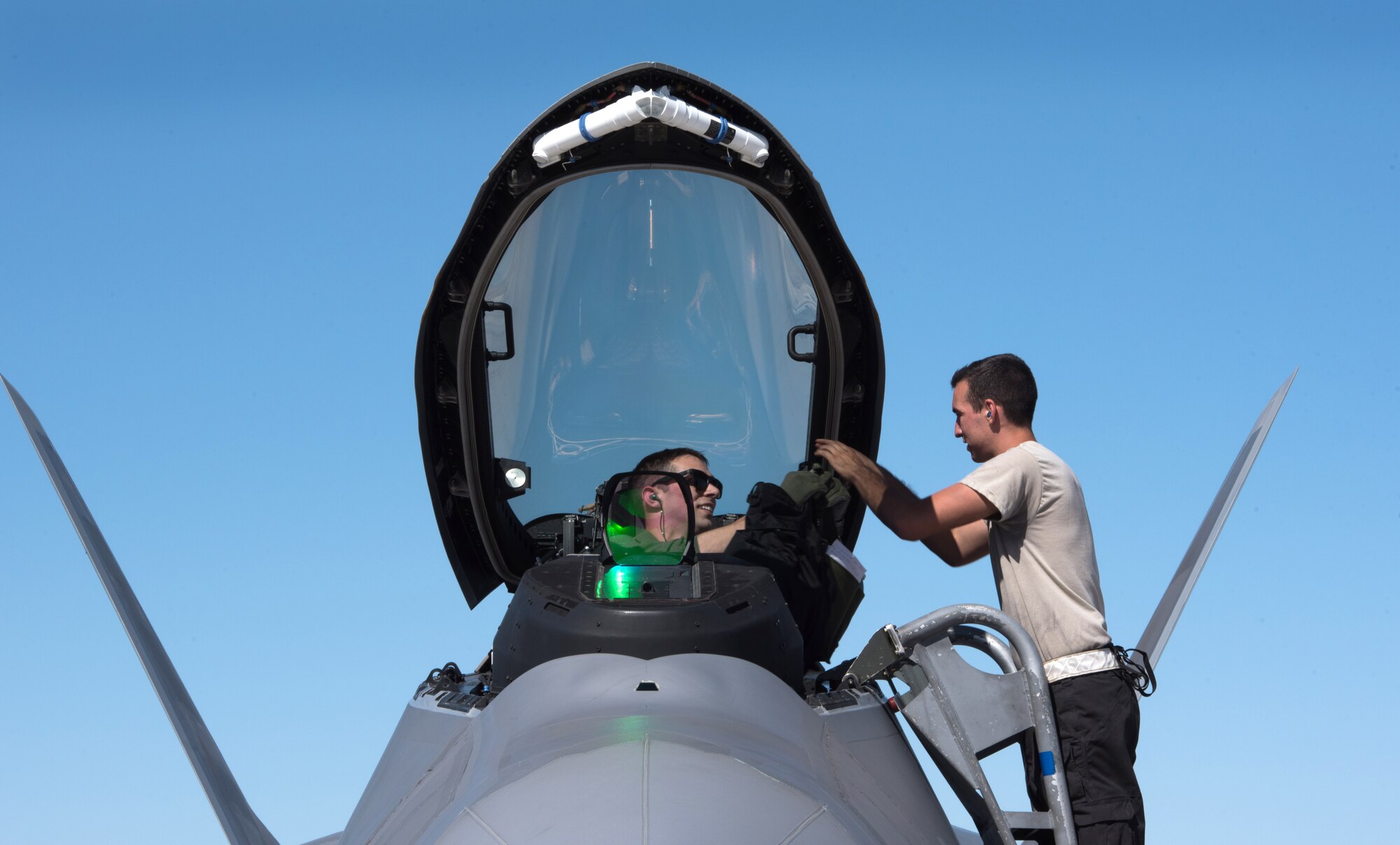 U.S. Air Force Airman Steven Quinn 27th Aircraft Maintenance Unit, crew chief assists Capt. Ramp, 94th Fighter Squadron, F-22 Raptor pilot after landing back at Nellis Air Force Base, Nev. Aug. 18, 2017. Quinn and Ramp are deployed with the 94th FS to take part in Red Flag 17-4 at Nellis AFB. (U.S. Air Force photo by Staff Sgt. Carlin Leslie)