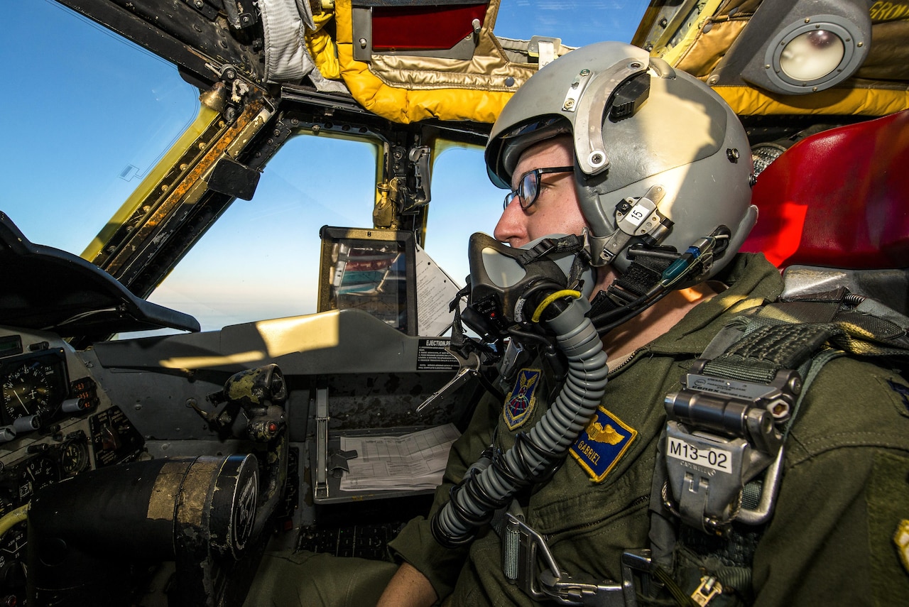 A pilot sits in a cockpit while operating an aircraft.