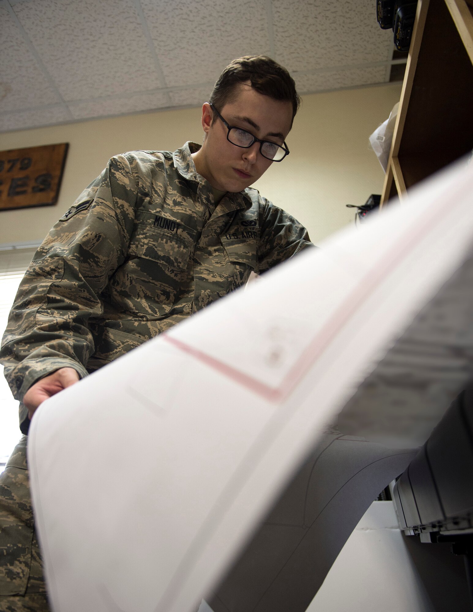 U.S Air Force Airman 1st Class Ryan Mudt, an engineering technician with the 379th Expeditionary Civil Engineer Squadron, reviews the quality of print at Al Udeid Air Base, Qatar, July 25, 2017.