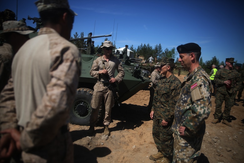 Brig. Gen. Helen G. Pratt, commanding general of 4th Marine Logistics Group, Marine Forces Reserve, and a Latvian soldier speak with U.S. Marines assigned to Marine Corps Forces Europe and Africa during a combined-arms live fire exercise aboard Adazi Military Base, Latvia, June 9, 2017. The event was a part of Exercise Saber Strike 17, a multinational training exercise with NATO Allies and partner nations to increase cohesion and skills through combined-arms training (U.S. Marine Corps photo by Cpl. Sean J. Berry)