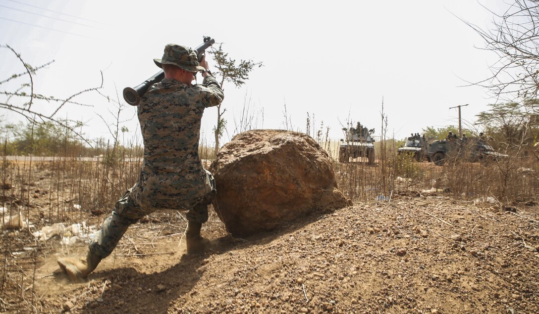 Lance Cpl. Johnathon Zwack, a motor transportation operator with Special Purpose Marine Air-Ground Task Force – Crisis Response – Africa, simulates an ambush on armored vehicles from Senegal’s 5th Contingent in Mali during a peacekeeping operations training mission at Thies, Senegal, June 7, 2017. Marines and Sailors with SPMAGTF-CR-AF served as instructors and designed the training to enhance the soldiers’ abilities to successfully deploy in support of United Nations peacekeeping missions in the continent. (U.S. Marine Corps photo by Sgt. Samuel Guerra/Released)