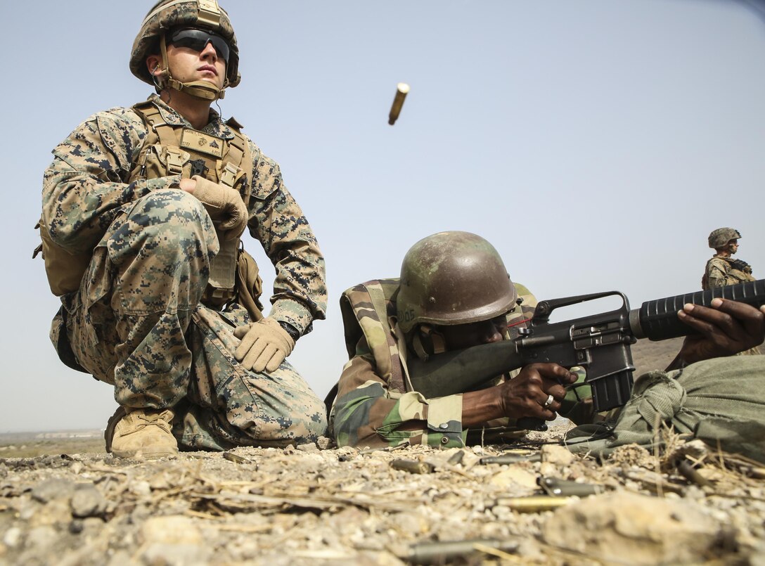 Cpl. Seth Carney, a rifleman with Special Purpose Marine Air-Ground Task Force – Crisis Response – Africa, observes the accuracy of a soldier with Senegal’s 5th Contingent in Mali during a peacekeeping operations training mission at Thies, Senegal, June 9, 2017. Marines and Sailors with SPMAGTF-CR-AF served as instructors and designed the training to enhance the soldiers’ abilities to successfully deploy in support of United Nations peacekeeping missions in the continent. (U.S. Marine Corps photo by Sgt. Samuel Guerra/Released)