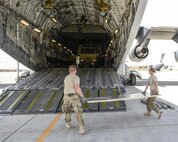 U.S. Air Force Staff Sgt. Leigh Sullivan, right, and Senior Airman Jonathan Moore, members of the cargo movement team assigned to the 557th Expeditionary RED HORSE Squadron lay plywood to protect a C-17 Globemaster III prior to loading an excavator onto the aircraft at Al Udeid Air Base, Qatar, Aug. 7, 2017. Members of the 557th ERHS loaded the 50,000 pound excavator into a C-17 Globemaster III aircraft for transportation to an undisclosed location in the U.S. Central Command Area of Responsibility. (U.S. Air National Guard photo by Tech. Sgt. Bradly A. Schneider/Released)