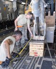 U.S. Air Force Senior Airman Jace Fore, standing, and Staff Sgt. Timothy Lees, kneeling with tape measure, both air transportation craftsmen assigned to the 8th Expeditionary Air Mobility Squadron, take measurements to make sure equipment loaded into a C-17 Globemaster III is properly positioned at Al Udeid Air Base, Qatar, Aug. 7, 2017. The 8th EAMS worked alongside the 557th Expeditionary RED HORSE Squadron to load a 50,000 pound excavator into a C-17 Globemaster III aircraft for transportation to an undisclosed location in the U.S. Central Command Area of Responsibility. (U.S. Air National Guard photo by Tech. Sgt. Bradly A. Schneider/Released)