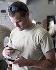 U.S. Air Force Senior Airman Jace Fore, air transportation craftsman assigned to the 8th Expeditionary Air Mobility Squadron, completes calculations to ensure proper load position of cargo inside a C-17 Globemaster III at Al Udeid Air Base, Qatar, Aug. 7, 2017. The 8th EAMS worked alongside the 557th Expeditionary RED HORSE Squadron to load a 50,000 pound excavator into a C-17 Globemaster III aircraft for transportation to an undisclosed location in the U.S. Central Command Area of Responsibility. (U.S. Air National Guard photo by Tech. Sgt. Bradly A. Schneider/Released)