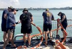 U.S. Navy and Marine Corps divers provide support to the USS John S. McCain (DDG 56) at Changi Naval Base, Singapore Aug. 23, 2017. The McCain sustained significant damage following a collision with the merchant vessel Alnic MC while underway east of the Strait of Malacca and Singapore on Aug. 21, 2017.