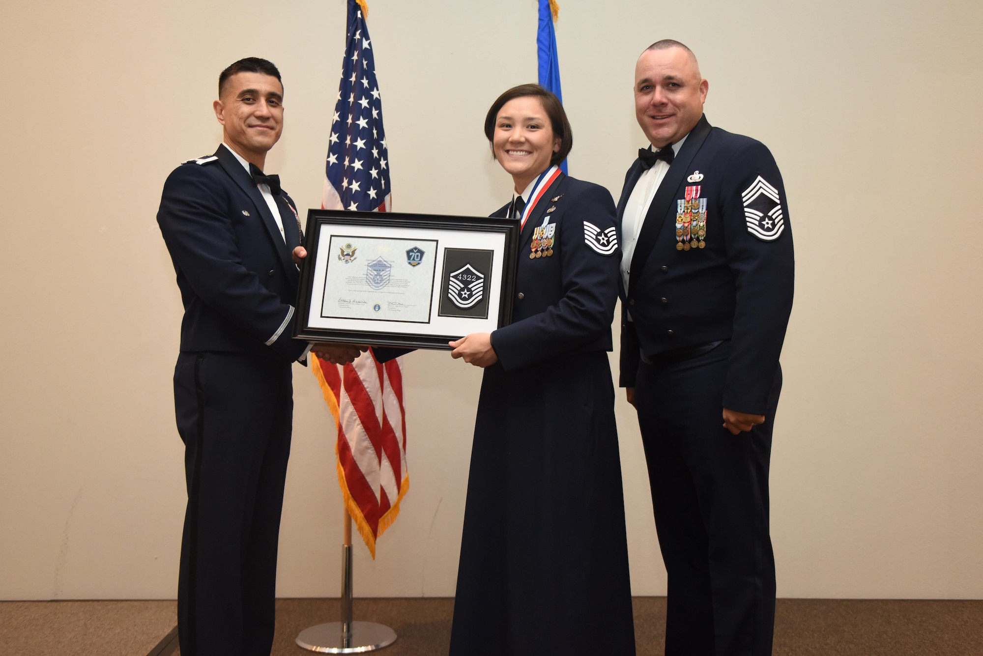 U.S. Air Force Tech. Sgt. Leanne Britt, 316th Training Squadron, receives their certificate of selection from Col. Ricky Mills, 17th Training Wing commander, and Chief Master Sgt. Daniel Stein, 17th Training Group superintendent, during the Senior NCO Induction Ceremony at the Event Center on Goodfellow Air Force Base, Texas, Aug. 18, 2017. (U.S. Air Force photo by Airman 1st Class Chase Sousa/Released)