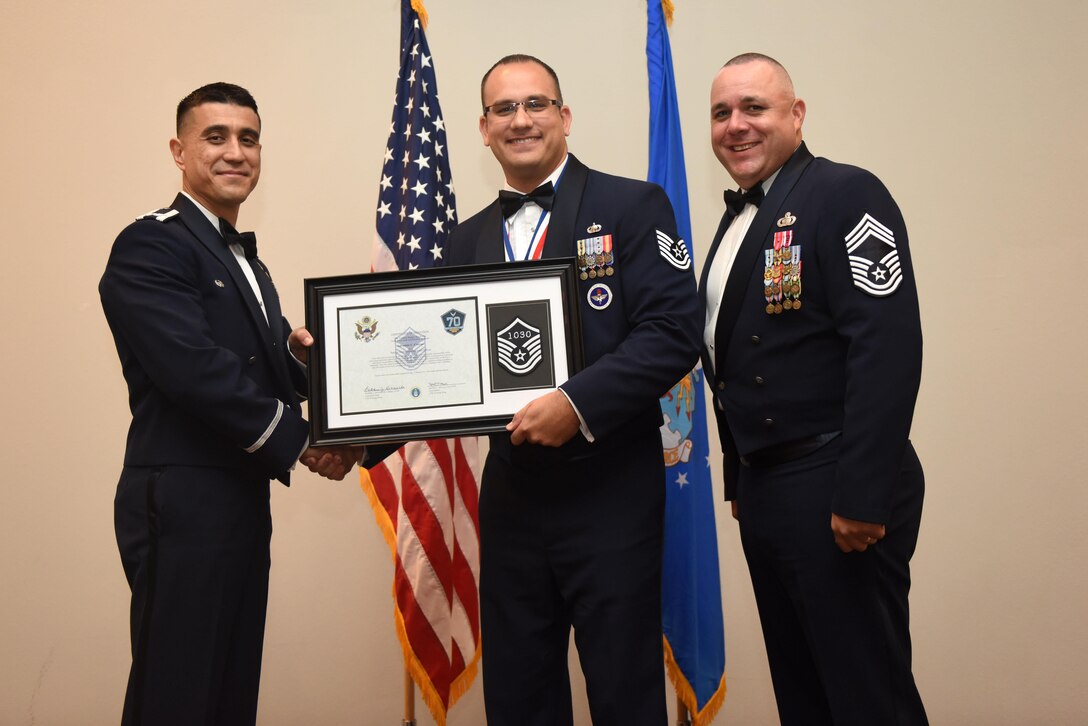 U.S. Air Force Tech. Sgt. Salvatore Corrao, 17th Training Support Squadron, receives their certificate of selection from Col. Ricky Mills, 17th Training Wing commander, and Chief Master Sgt. Daniel Stein, 17th Training Group superintendent, during the Senior NCO Induction Ceremony at the Event Center on Goodfellow Air Force Base, Texas, Aug. 18, 2017. (U.S. Air Force photo by Airman 1st Class Chase Sousa/Released)