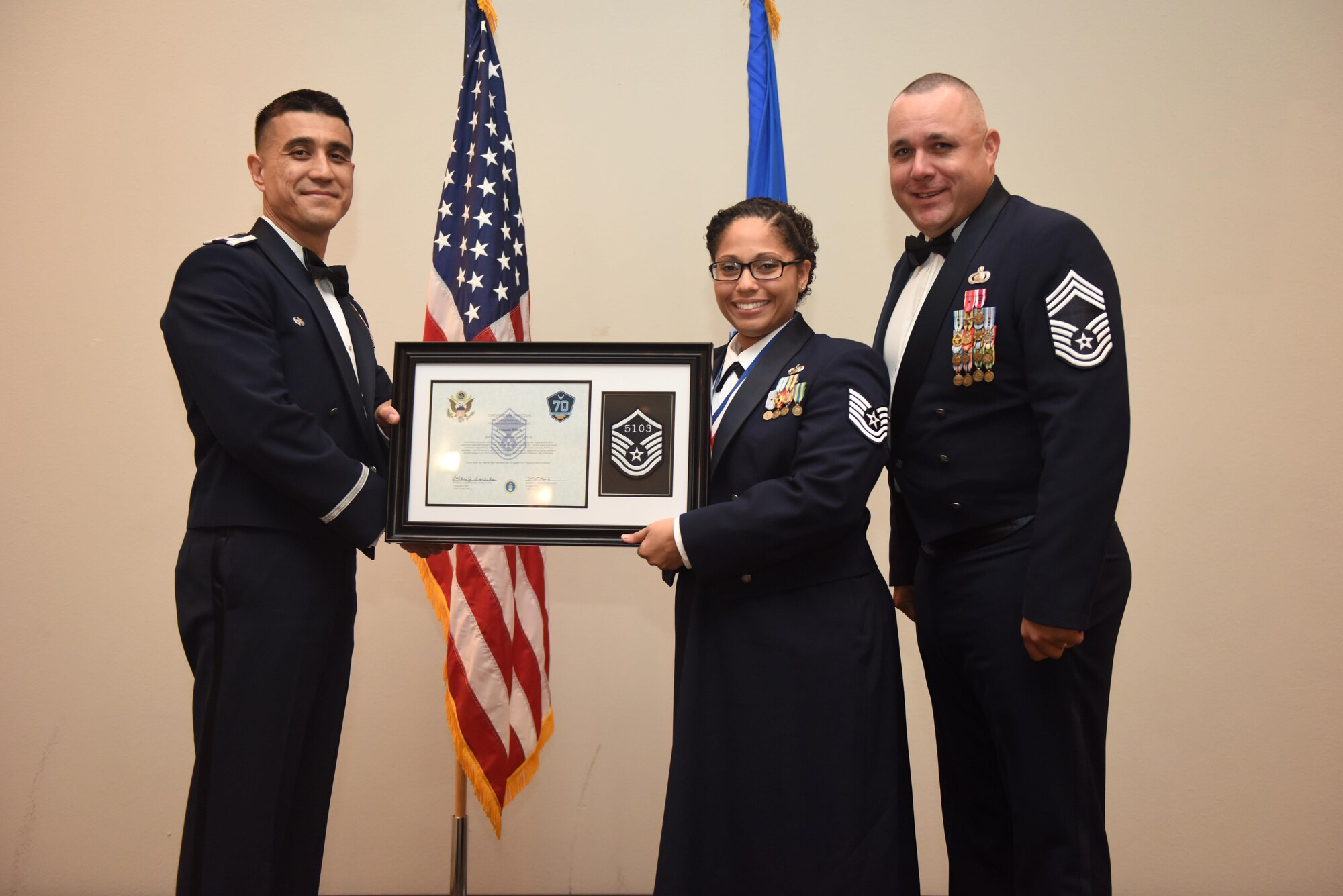 U.S. Air Force Tech. Sgt. Stephanie Elliott, 17th Training Wing, receives their certificate of selection from Col. Ricky Mills, 17th Training Wing commander, and Chief Master Sgt. Daniel Stein, 17th Training Group superintendent, during the Senior NCO Induction Ceremony at the Event Center on Goodfellow Air Force Base, Texas, Aug. 18, 2017. (U.S. Air Force photo by Airman 1st Class Chase Sousa/Released)