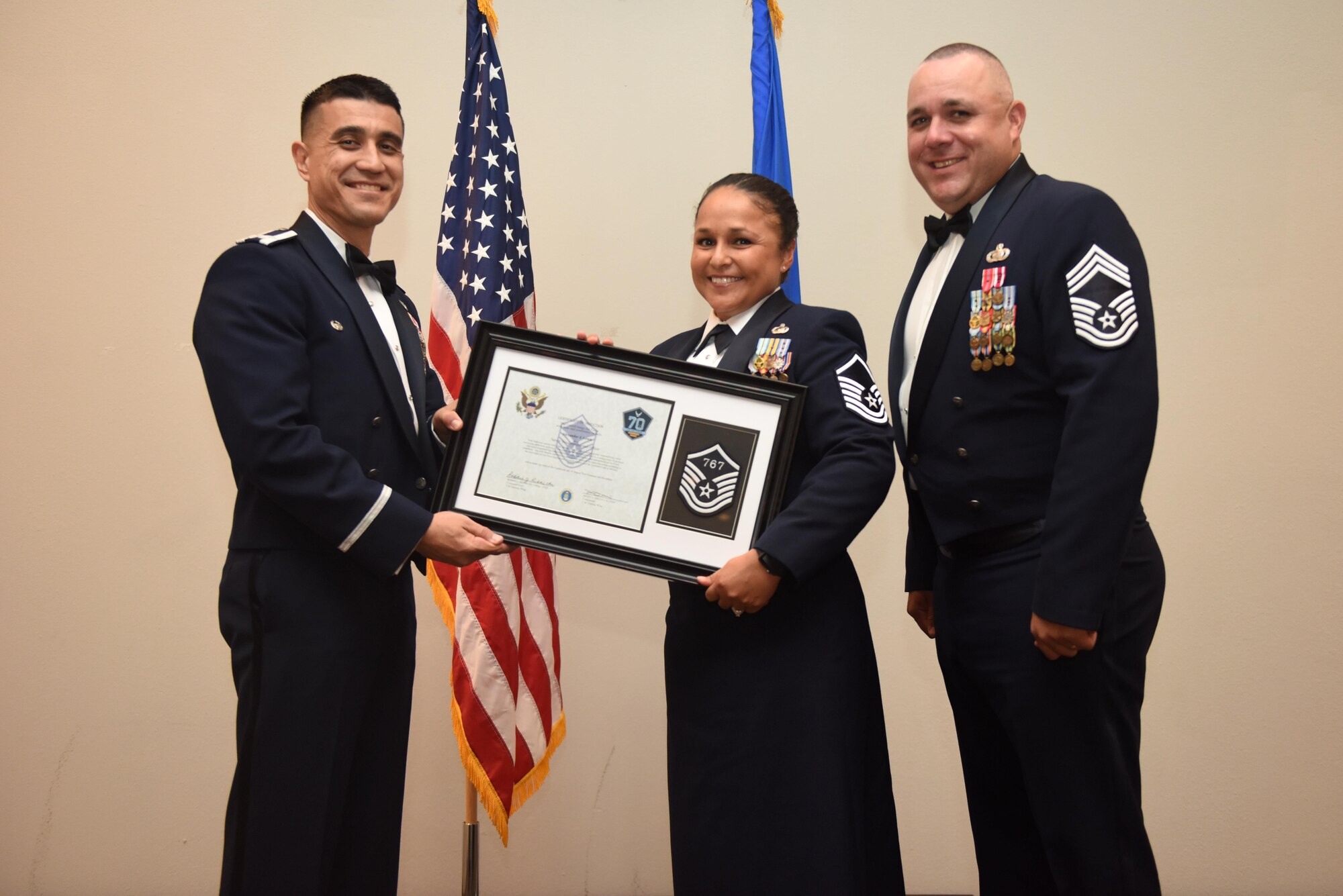 U.S. Air Force Master Sgt. Alexander Lewis, 315th Training Squadron, receives their certificate of selection from Col. Ricky Mills, 17th Training Wing commander, and Chief Master Sgt. Daniel Stein, 17th Training Group superintendent, during the Senior NCO Induction Ceremony at the Event Center on Goodfellow Air Force Base, Texas, Aug. 18, 2017. (U.S. Air Force photo by Airman 1st Class Chase Sousa/Released)