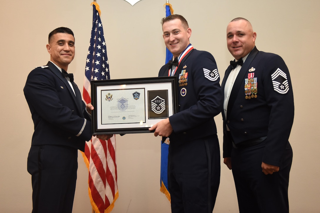 U.S. Air Force Tech. Sgt. Martin Smith, 315th Training Squadron, receives their certificate of selection from Col. Ricky Mills, 17th Training Wing commander, and Chief Master Sgt. Daniel Stein, 17th Training Group superintendent, during the Senior NCO Induction Ceremony at the Event Center on Goodfellow Air Force Base, Texas, Aug. 18, 2017. (U.S. Air Force photo by Airman 1st Class Chase Sousa/Released)