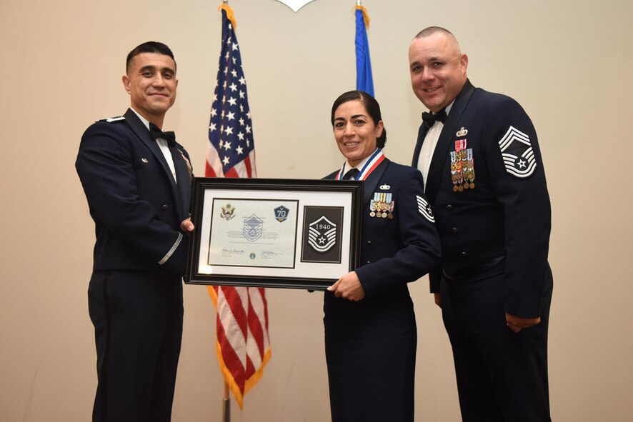 U.S. Air Force Tech. Sgt. Rosanna Surber, 17th Comptroller Squadron, receives their certificate of selection from Col. Ricky Mills, 17th Training Wing commander, and Chief Master Sgt. Daniel Stein, 17th Training Group superintendent, during the Senior NCO Induction Ceremony at the Event Center on Goodfellow Air Force Base, Texas, Aug. 18, 2017. (U.S. Air Force photo by Airman 1st Class Chase Sousa/Released)