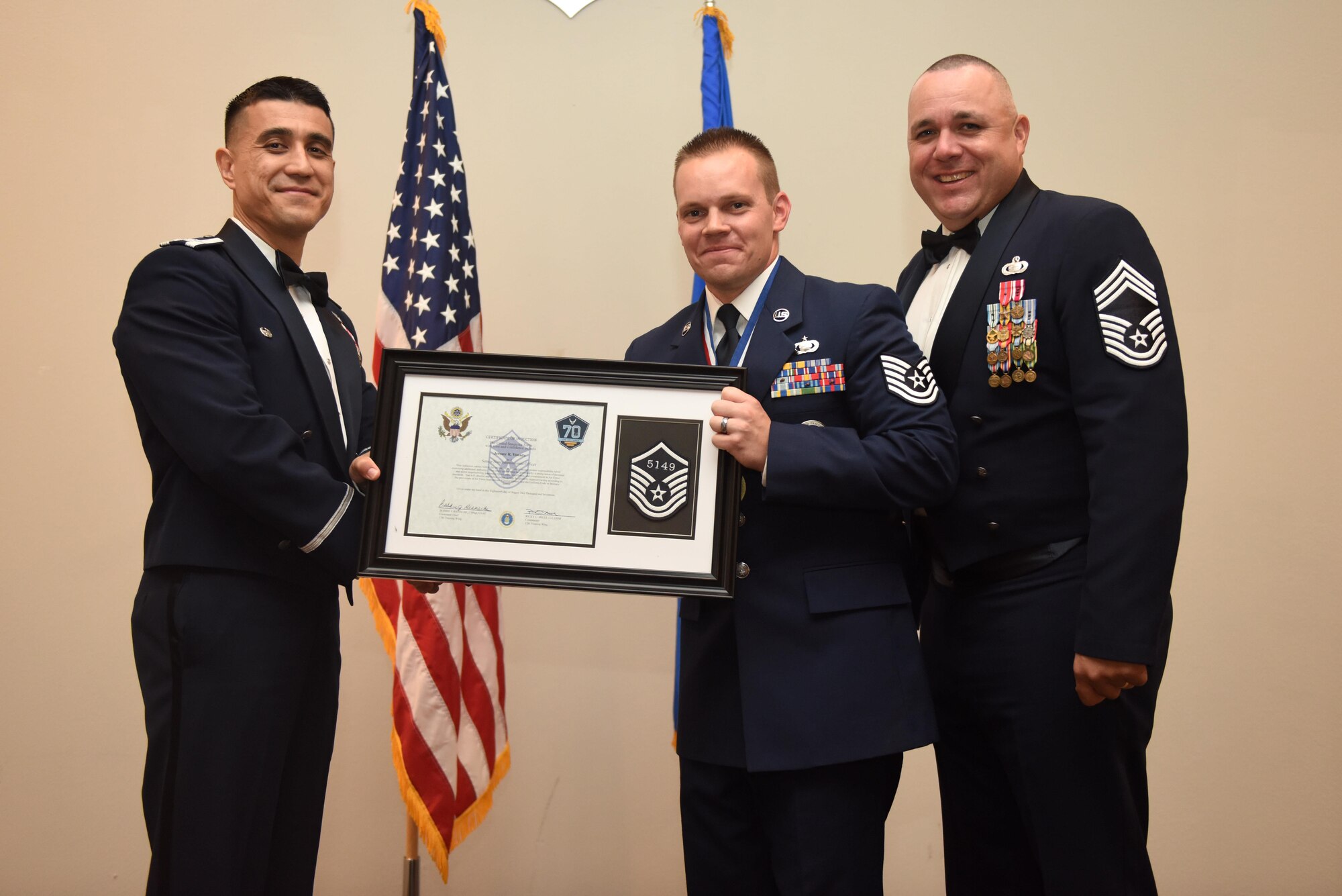 U.S. Air Force Tech. Sgt. Jeremy Vonada, 316th Training Squadron, receives their certificate of selection from Col. Ricky Mills, 17th Training Wing commander, and Chief Master Sgt. Daniel Stein, 17th Training Group superintendent, during the Senior NCO Induction Ceremony at the Event Center on Goodfellow Air Force Base, Texas, Aug. 18, 2017. (U.S. Air Force photo by Airman 1st Class Chase Sousa/Released)
