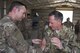 Maj. Robert Coan, 557th Expeditionary RED HORSE detachment commander, left, places a RED HORSE patch on Air Force Chief of Staff Gen. David L. Goldfein during a tour of the 332nd Air Expeditionary Wing, August 21, 2017, in Southwest Asia. While visiting the construction site, Goldfein and Secretary of the Air Force Heather Wilson where briefed about current project to improve the 332nd AEW. (U.S. Air Force photo/Senior Airman Damon Kasberg)