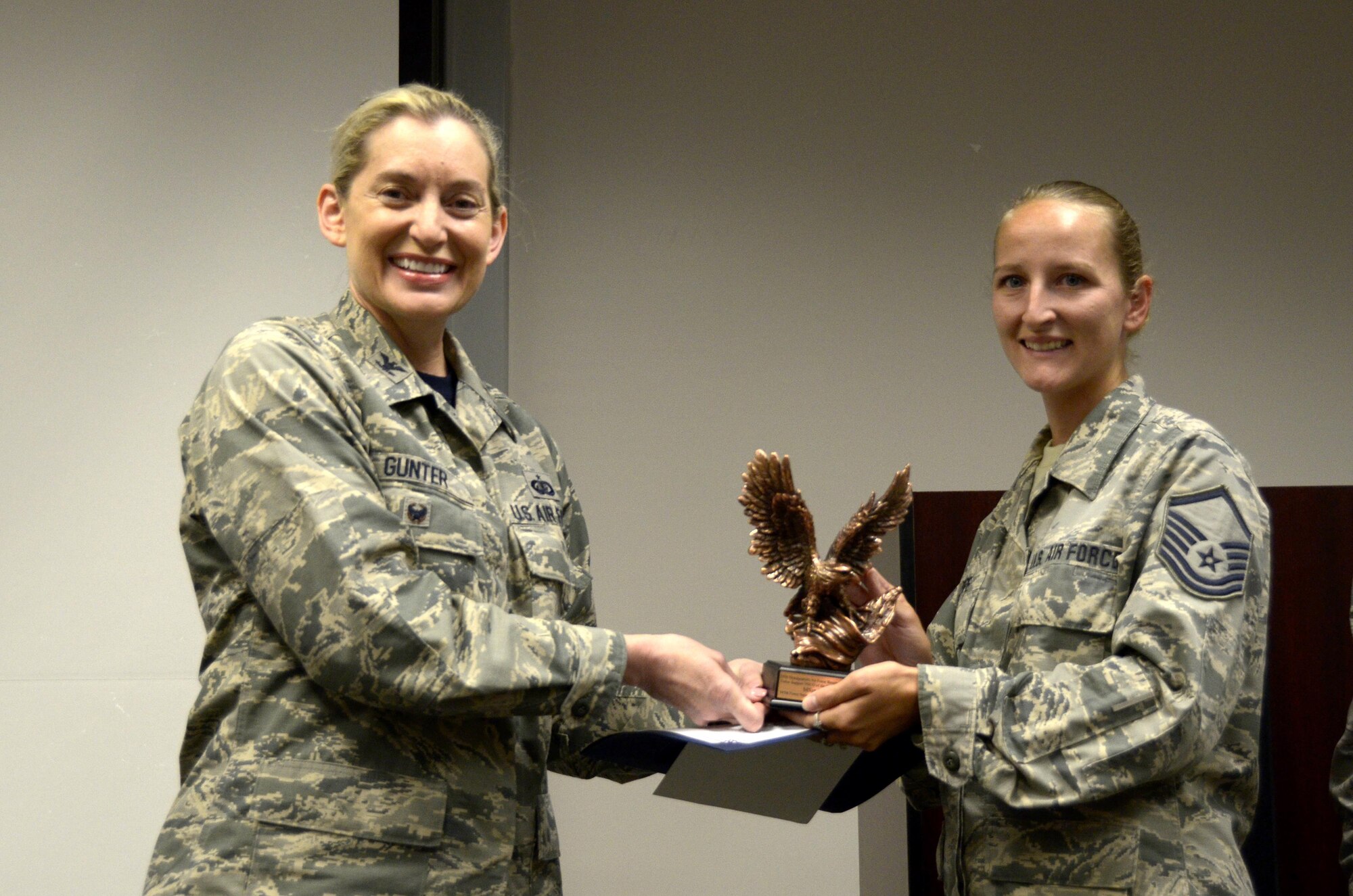 Master Sgt. Jamie Pope, 445th Force Support Squadron NCO in charge of customer support, is presented with the Force Support Senior NCO of the Year by Col. Anne Gunter, director of manpower, personnel and services, Air Force Reserve Command, Robins Air Force Base, Georgia, August 5, 2017. (U.S. Air Force photo/Staff Sgt. Joel McCullough)