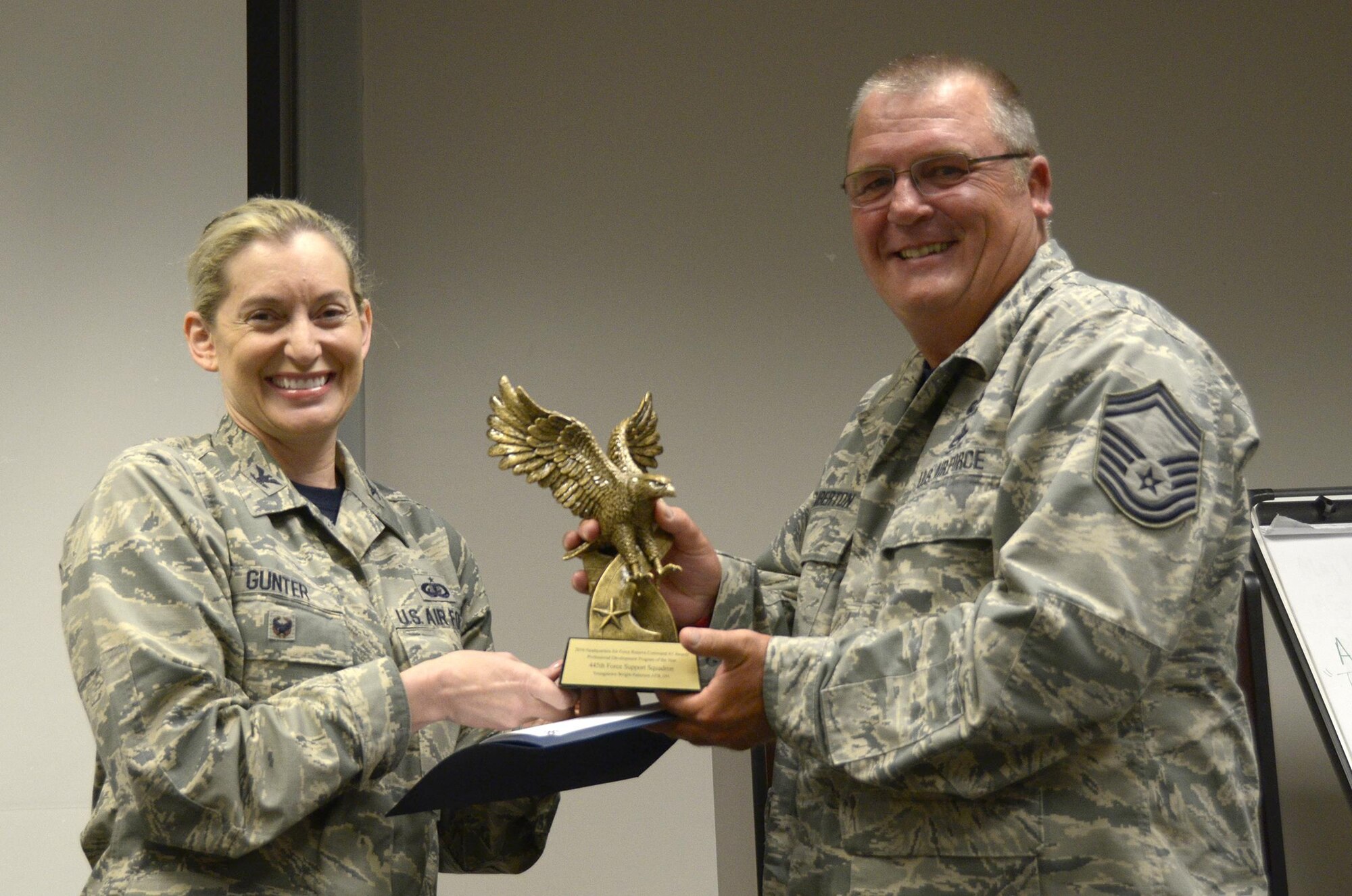 Senior Master Sgt. Timothy Emberton, 445th Force Support Squadron superintendent of training, is presented with the Professional Development Program of the Year award presented to FSS by Col. Anne Gunter, director of manpower, personnel and services, Air Force Reserve Command, Robins Air Force Base, Georgia, August 5, 2017. (U.S. Air Force photo/Staff Sgt. Joel McCullough)