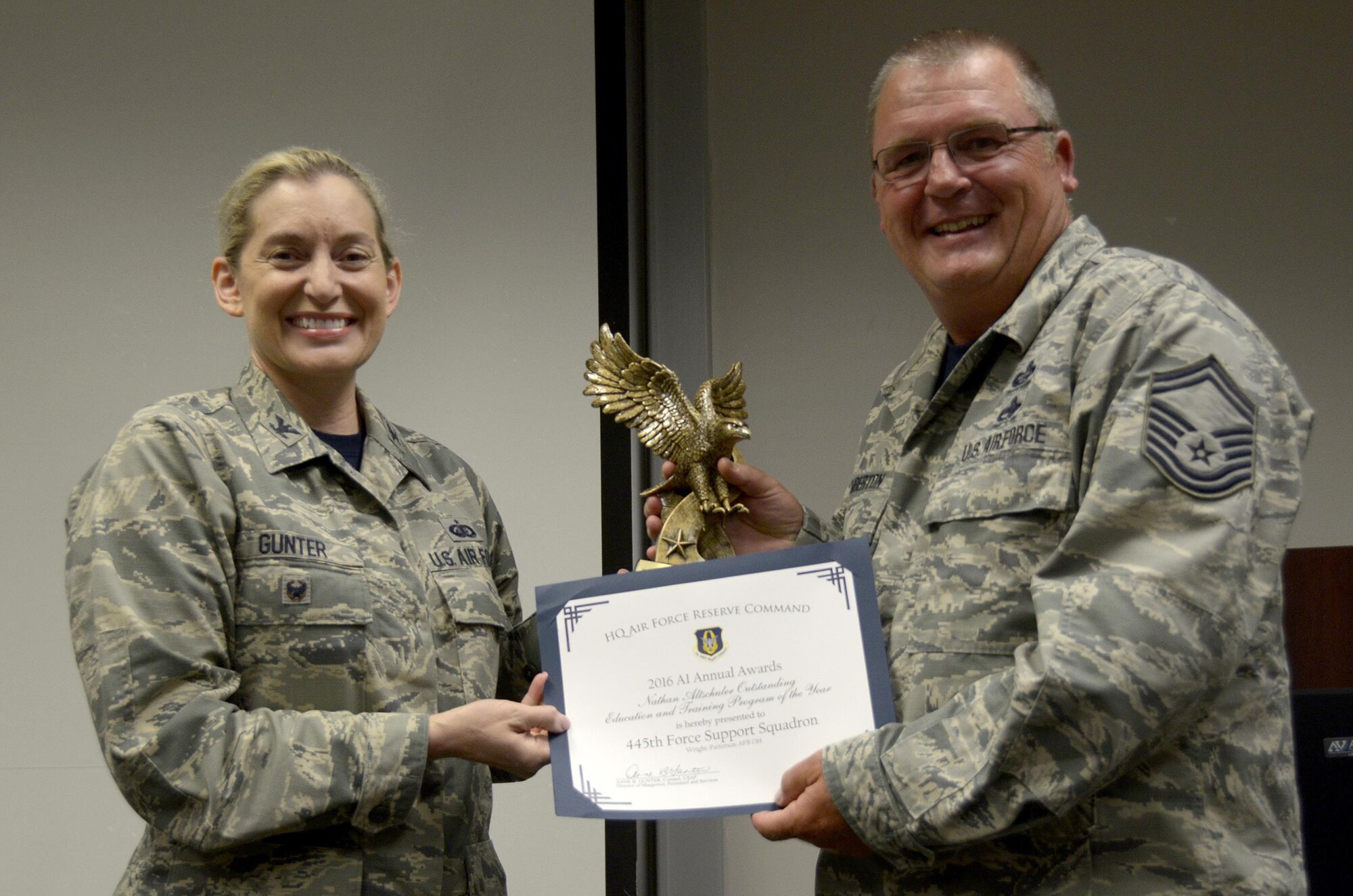 Senior Master Sgt. Timothy Emberton, 445th Force Support Squadron superintendent of training, is presented with the Nathan Altschuler Outstanding Education and Training Program of the Year awarded to FSS by Col. Anne Gunter, director of manpower, personnel and services, Air Force Reserve Command, Robins Air Force Base, Georgia, August 5, 2017.