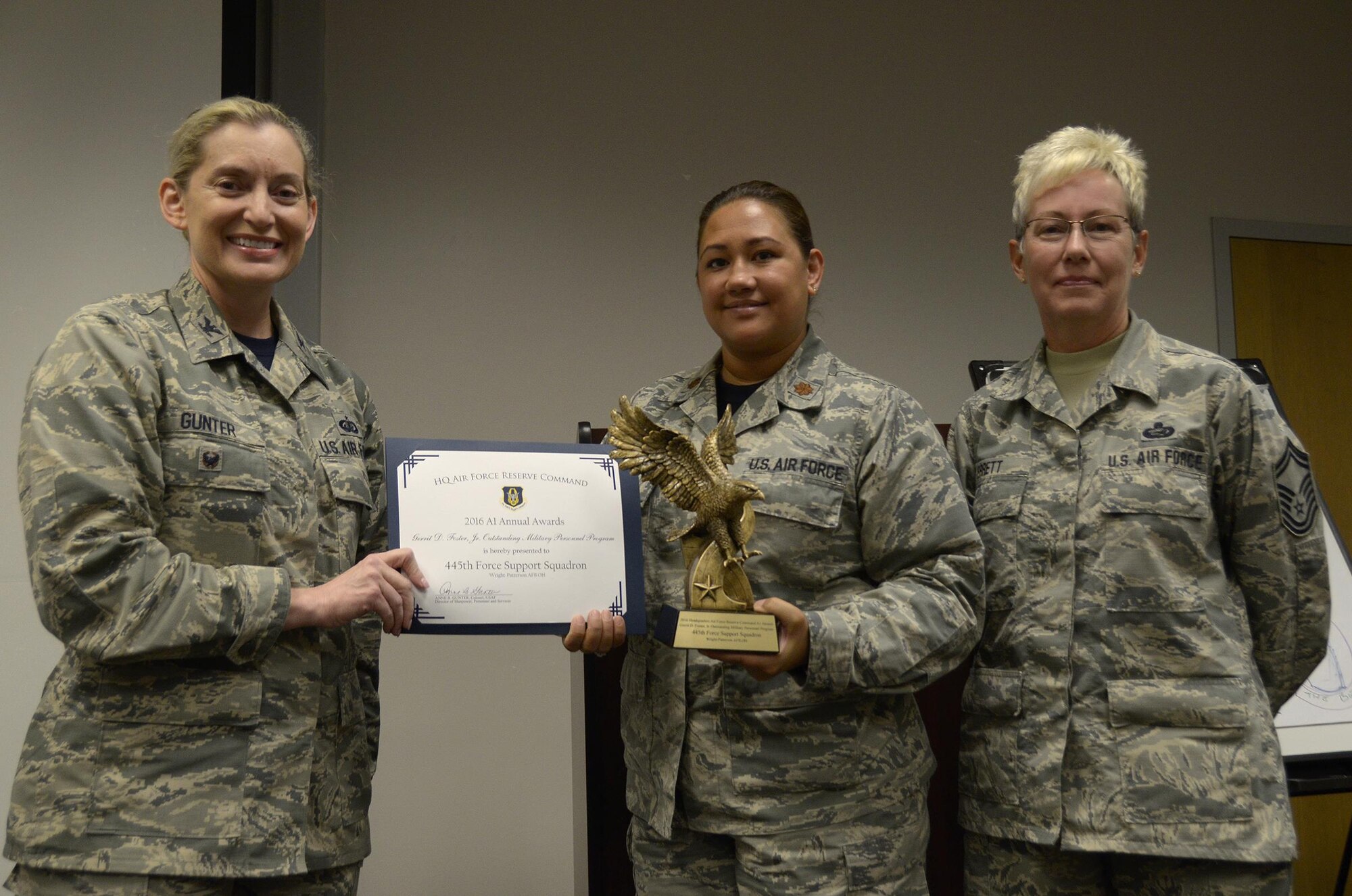 Col. Anne Gunter, director of manpower, personnel and services, Air Force Reserve Command, Robins Air Force Base, Georgia, presents the Gerrit D. Foster, Jr. Outstanding Military Personnel Program award to Maj. Sabrina Ocampo, 445 FSS personnel officer and Senior Master Sgt. Victoria Errett, 445 FSS MPS superintendent, August 5, 2017. (U.S. Air Force photo/Staff Sgt. Joel McCullough)