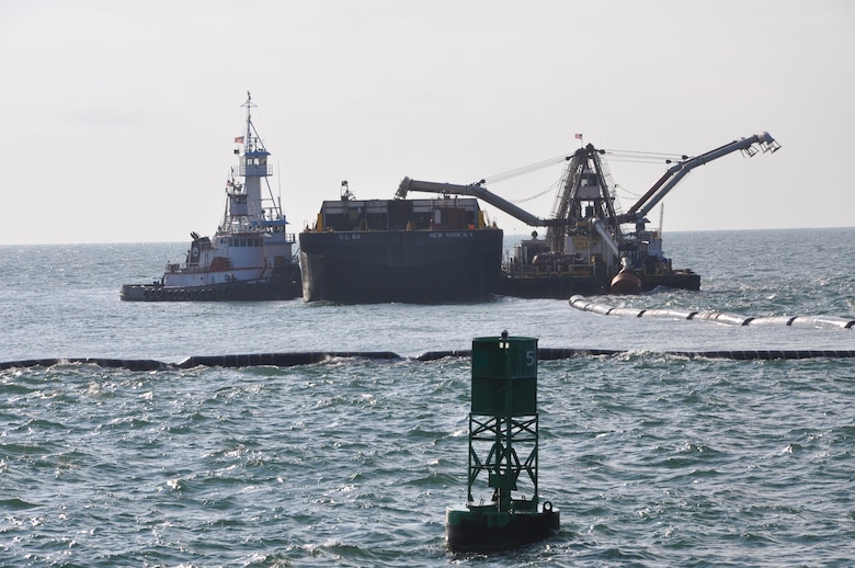 A Spider Barge (right) distributes outer-channel sediment into a barge held in place by a tug boat (left), as a Cutter Head Dredge Alaska (outside frame) pumps material through the pipe. The work is part of the Savannah Harbor Expansion Project. The outer channel will extend up to 20 miles into the Atlantic when complete, making the entire shipping channel 40 miles long from entry to Garden City Terminal.