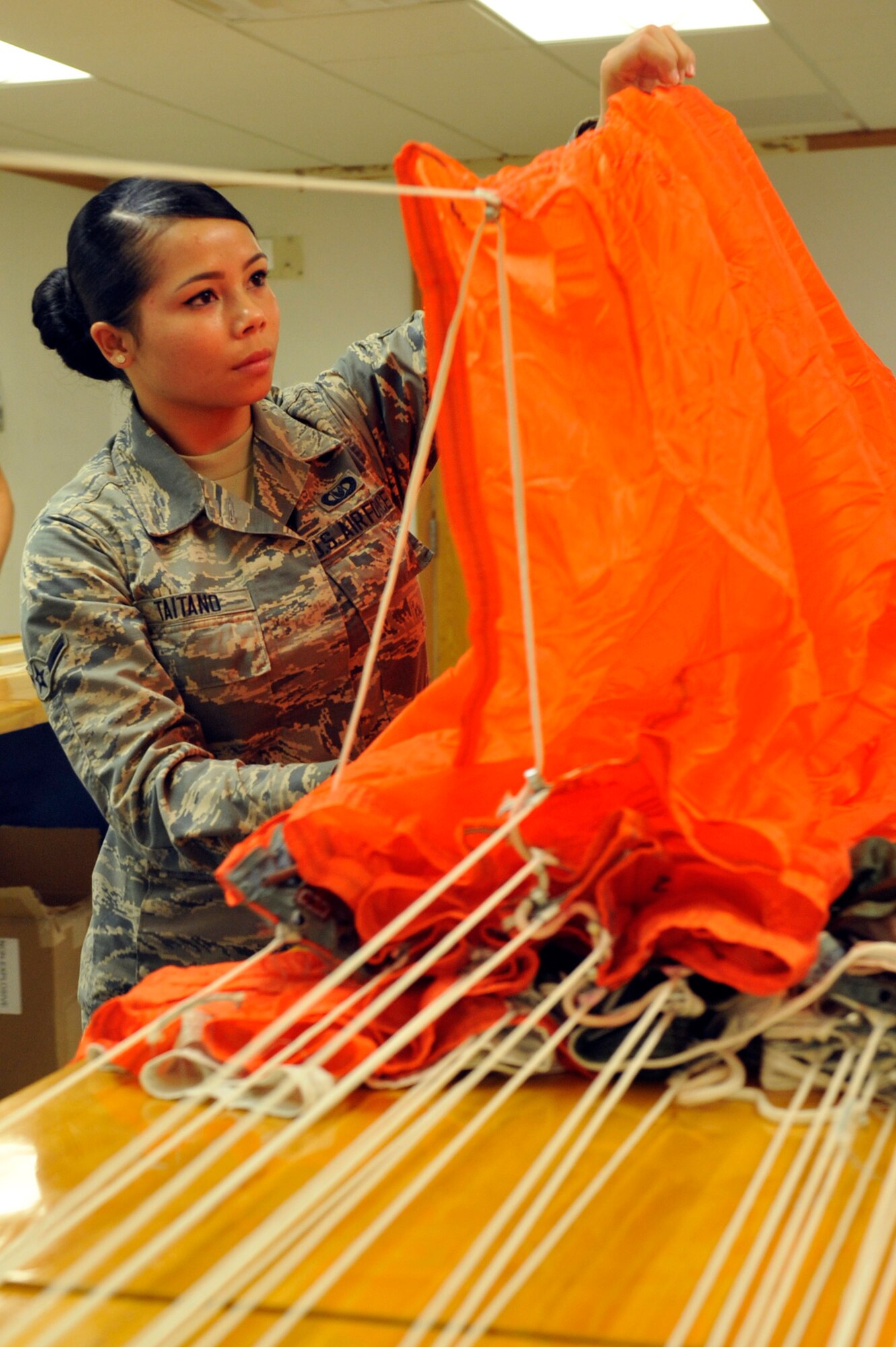 Airman Laura Taitano, 56th Operation Support Squadron aircrew flight equipment apprentice, inspects a parachute August 18,2017, at Luke Air Force Base, Ariz. These types of parachutes are maintained and packed for Taiwan fighter pilots. (U.S. Air Force photo/Airman 1st Class Pedro Mota)