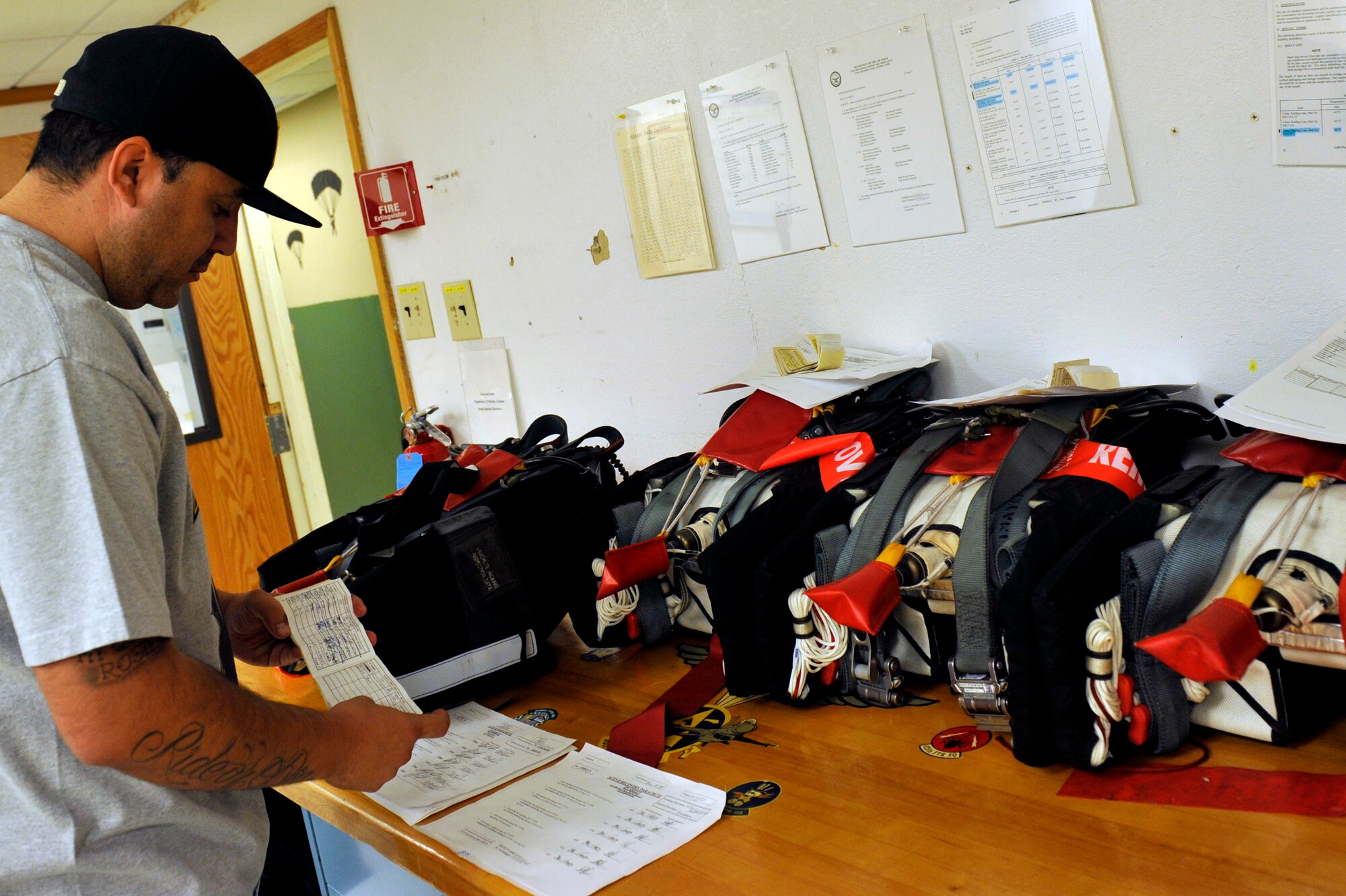 Juan Gonzalez, 56th Operation Support Squadron aircrew flight equipment civil serviceman, inspects post packaged parachutes August 18, 2017, at Luke Air Force Base, Ariz. The parachutes are carefully handled throughout the inspection due to the explosive cutter device. (U.S. Air Force photo/Airman 1st Class Pedro Mota)