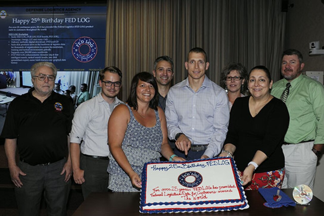 Group of civilians facing viewer, holding sheet cake