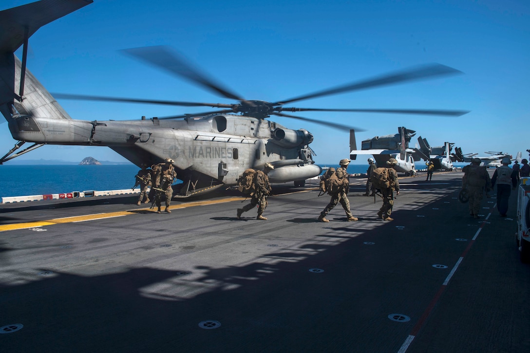 Marines disembark from a CH-53E Super Stallion helicopter.