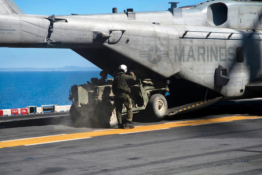 Marines offload an internally transportable vehicle from a CH-53E Super Stallion helicopter