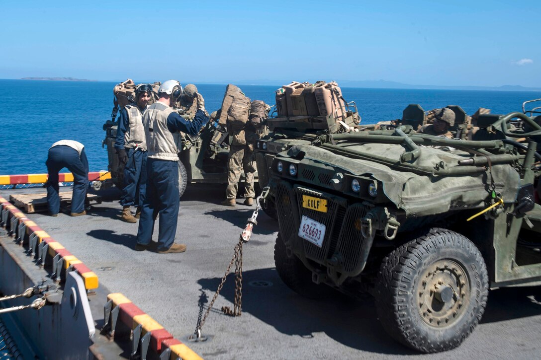 Marines park internally transportable vehicles on the starboard aircraft elevator.