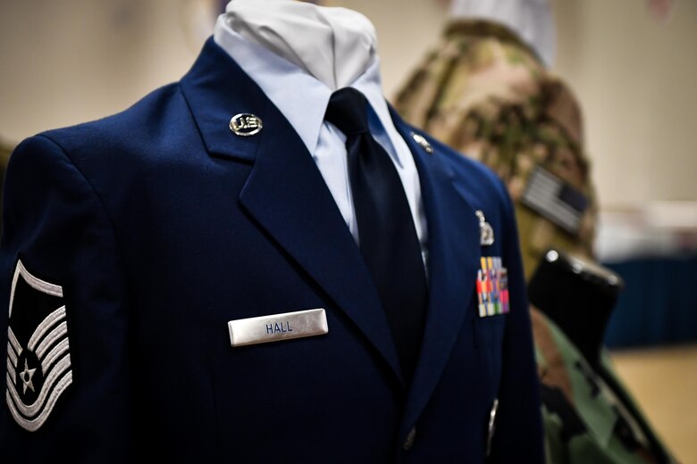 Uniforms from different eras are displayed with master sergeant Stripes during the 2017 Senior NCO induction ceremony at Barksdale Air Force Base, La., Aug. 18. The uniform display included a current service dress uniform, an out of service Battle Dress Uniform and a flight suit.