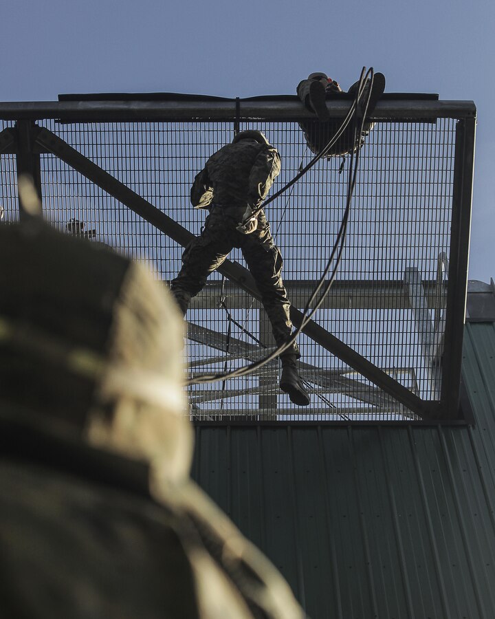 U.S. Marine Corps Corporal Lucas Anderson, 3rd Team Leader, 2nd Squad, with 2nd Battalion, 23rd Marine Regiment, 4th Marine Division, Marine Forces Reserve, drops down from a simulated helo pad during the helo, insertion and mountain rappelling exercise on Camp Carroll, Joint Base Elmendorf-Richardson, Alaska, Aug. 4, 2017.  Super Squad Competitions were designed to evaluate a 14-man infantry squad throughout an extensive field and live-fire evolution. (U.S. Marine Corps photo by Sgt. Justin A. Bopp/Released)