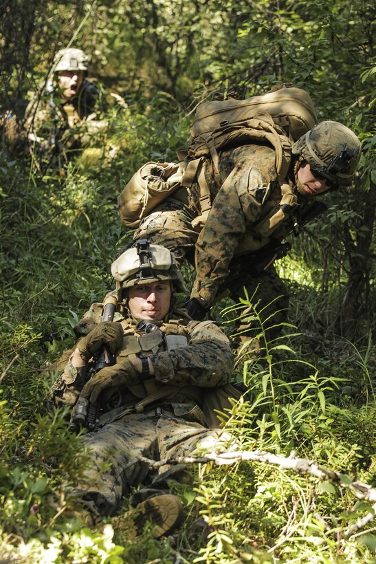 U.S. Navy Corpsman, Petty Officer 2nd Class Christopher Covino with Super Squad Competition 1st Squad, out of 1st Battalion, 25th Marine Regiment, 4th Marine Division, Marine Forces Reserve, drags one of the squad members under his care to a safe position while conducting offensive/defensive field operations on Joint Base Elmendorf-Richardson, Alaska, Aug. 6, 2017.